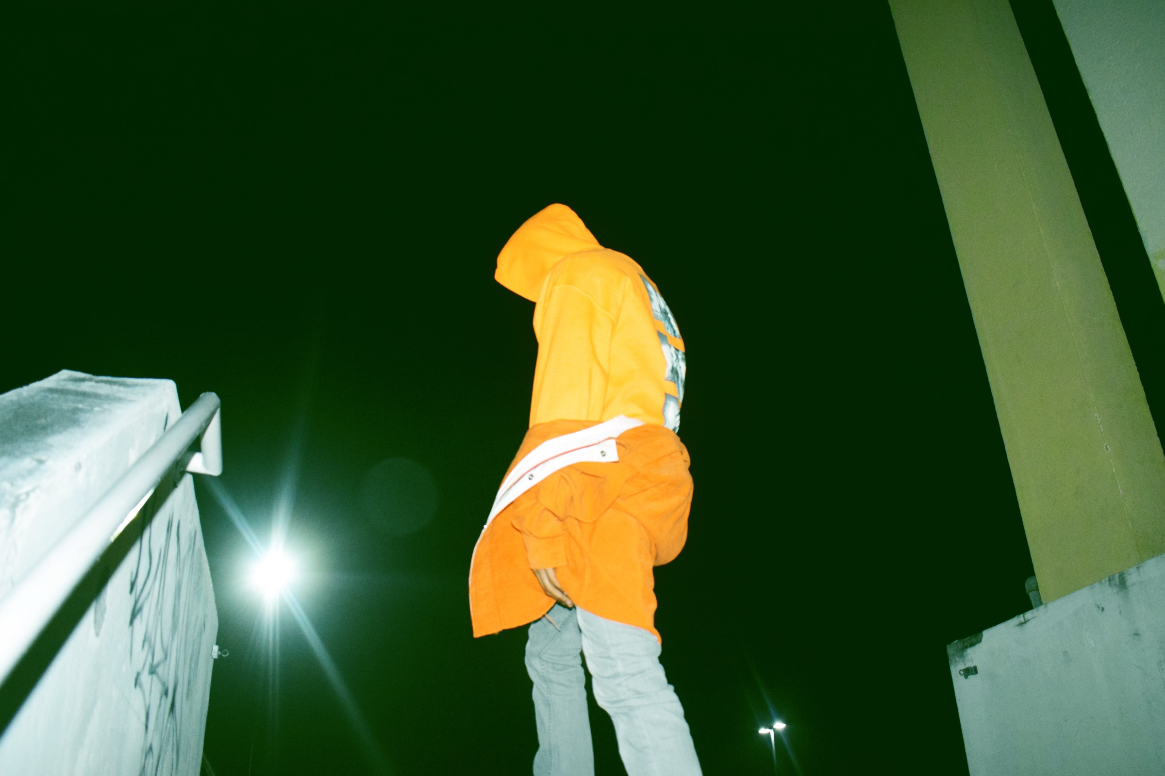Figure in orange photographed at night by BLUR DIGITAL
